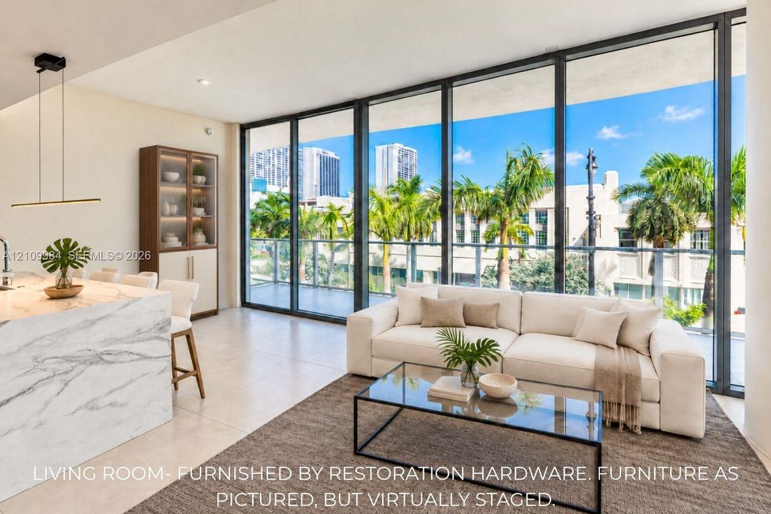 Floor-to-ceiling glass wall, expansive private balcony, stone-finish kitchen island with waterfall edge, built-in cabinetry, and large-format tile flooring