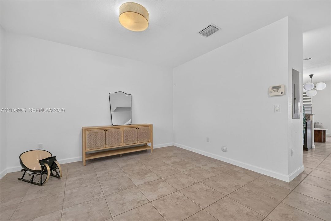 Neutral-toned tile flooring, minimalist ceiling-mounted drum lighting, and crisp white wall finishes