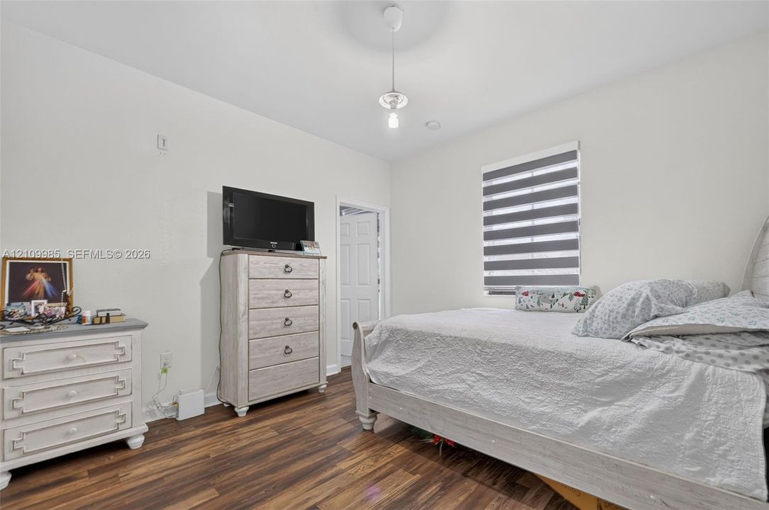 Wood-finish flooring, dual-pane window with integrated day-night shade, and paneled interior door