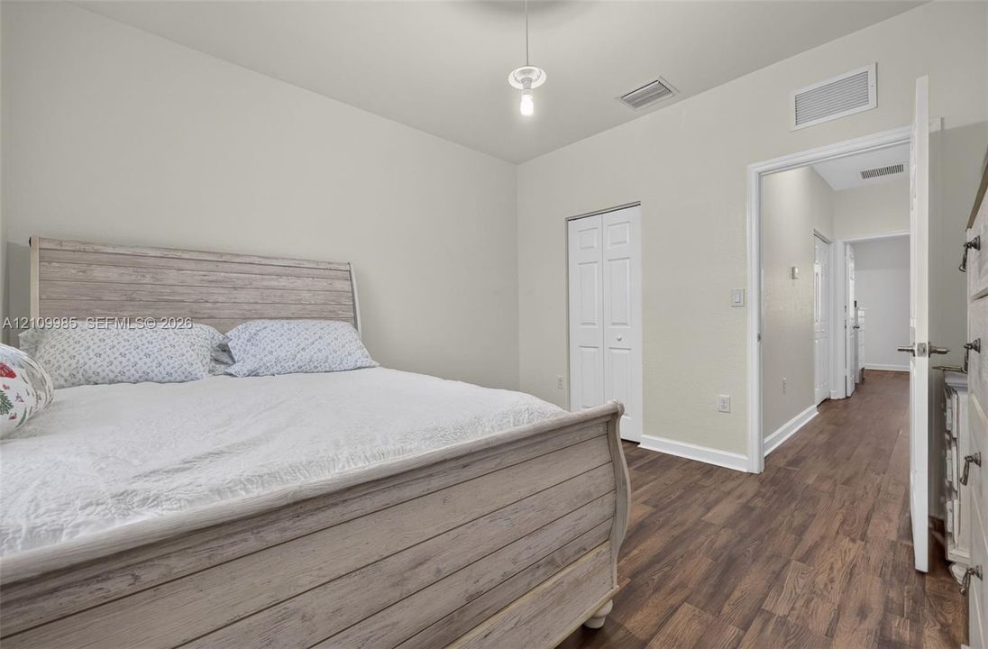 Wood-finish flooring, neutral wall color, and double-panel interior closet doors