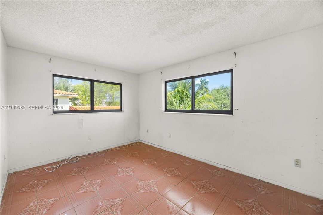 Interior room featuring tile flooring with decorative detailing and two horizontal sliding windows with dark frames