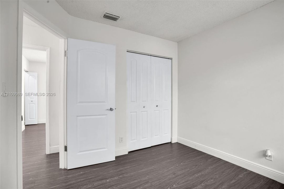 Interior space featuring wood-finish flooring, two-panel interior doors, and a double-door closet