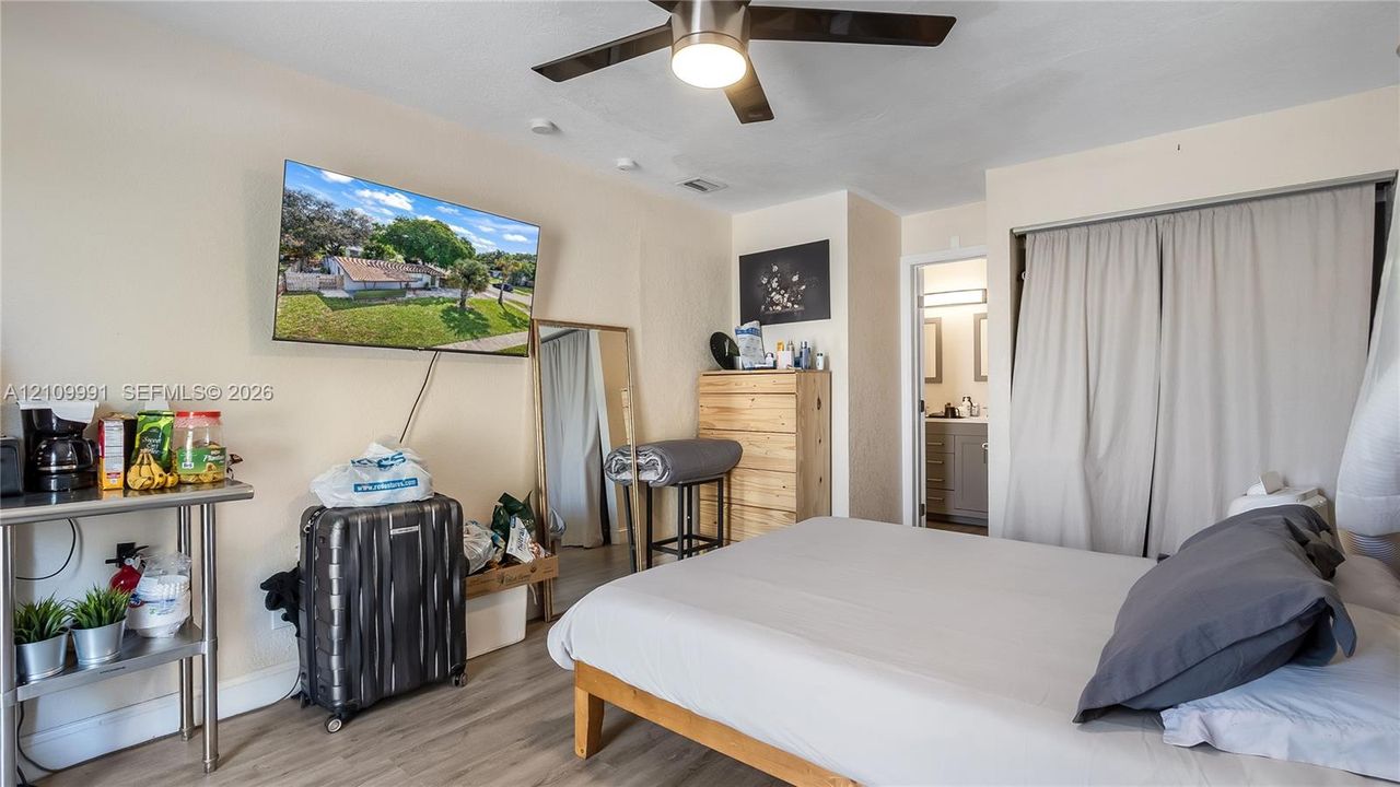 Interior room featuring wood-finish flooring, a ceiling fan with integrated lighting, and a closet with sliding panel doors