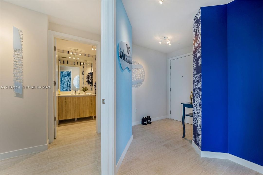 Foyer featuring wood-finish flooring, recessed ceiling lighting, and a bathroom showcasing a wood-finish vanity with an integrated countertop