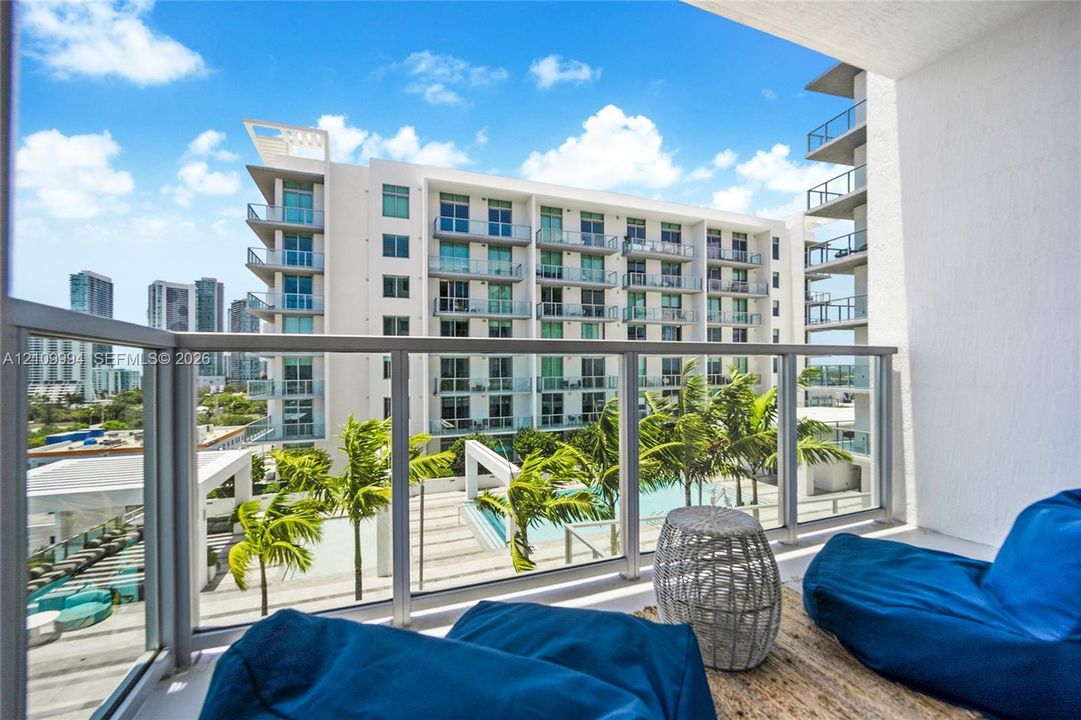 Private balcony featuring glass panel railing, metal frame, and concrete flooring