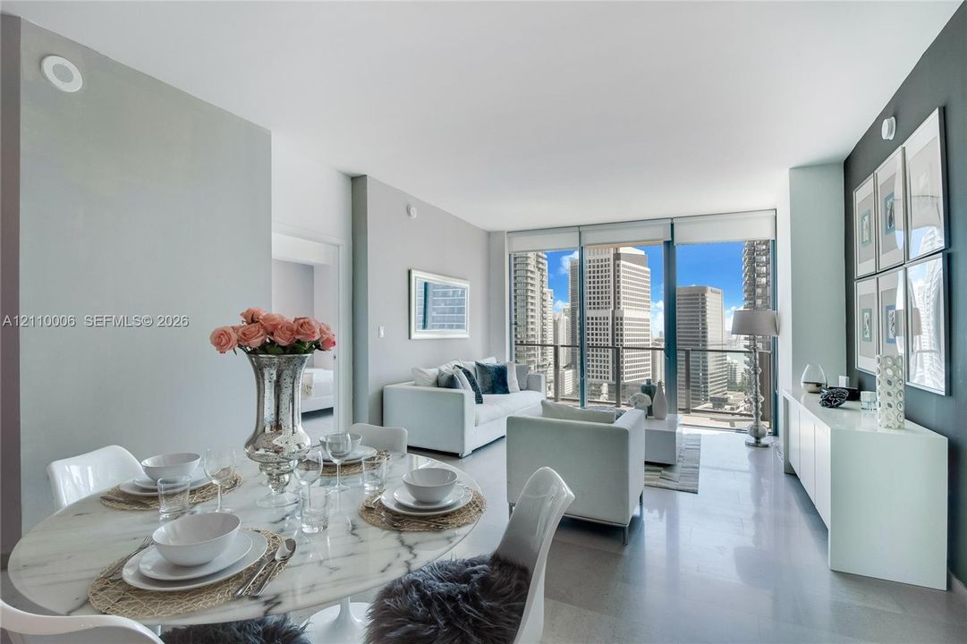 Floor-to-ceiling windows, polished concrete flooring, neutral wall palette, and expansive urban skyline backdrop