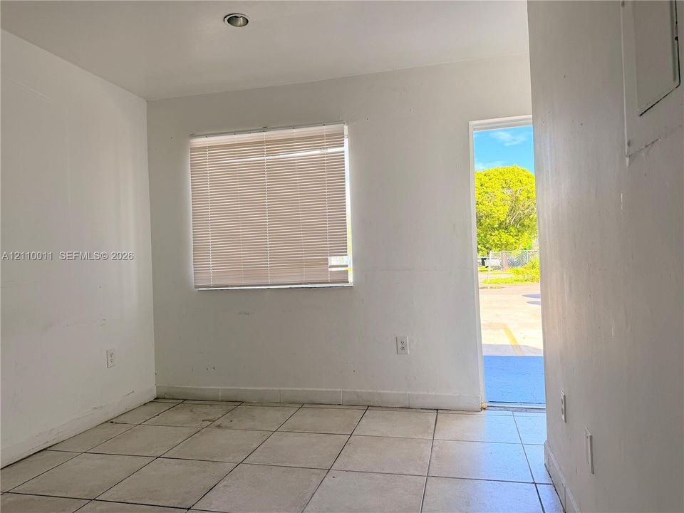 Interior space featuring neutral wall paint, tile flooring, a recessed ceiling light, and a window with horizontal blinds
