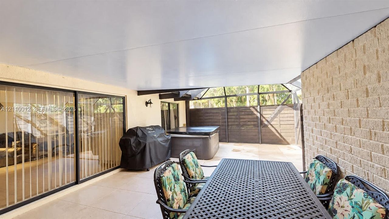 Covered patio featuring concrete tile flooring, a screen-enclosed area, and masonry exterior wall