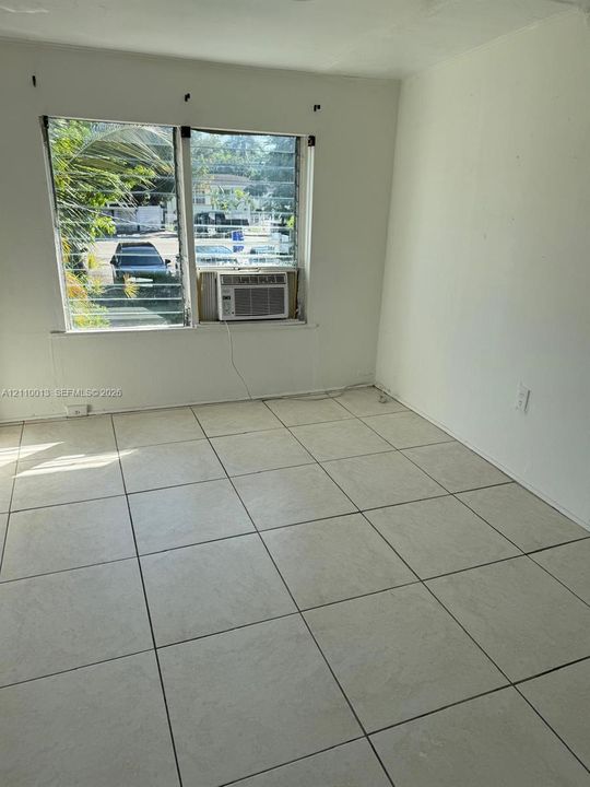 Neutral-toned tile flooring throughout with large-format glass jalousie windows