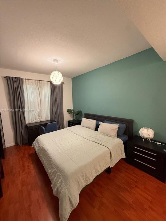 Wood-finish flooring, accent wall, and pendant light fixture