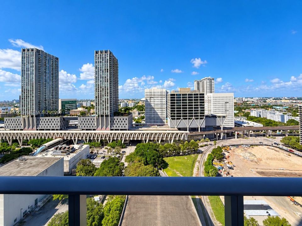 Elevated balcony with a dark metal railing featuring an expansive metropolitan skyline backdrop