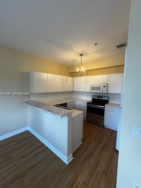 Kitchen featuring white cabinetry, stone-finish countertops, stainless steel appliances, and wood-finish flooring