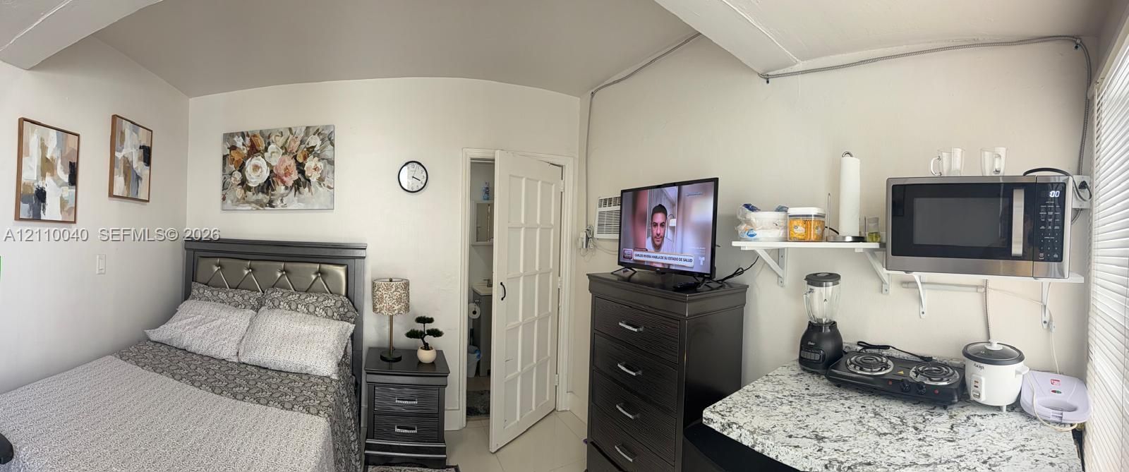 Multi-purpose interior space featuring a stone-patterned countertop, wall-mounted shelving, and a glass-paneled wooden door