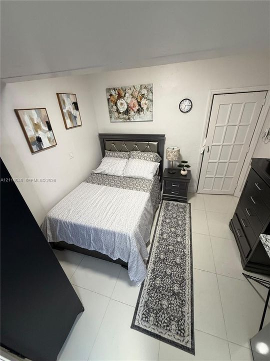 Room interior featuring polished tile flooring and a multi-lite paneled door