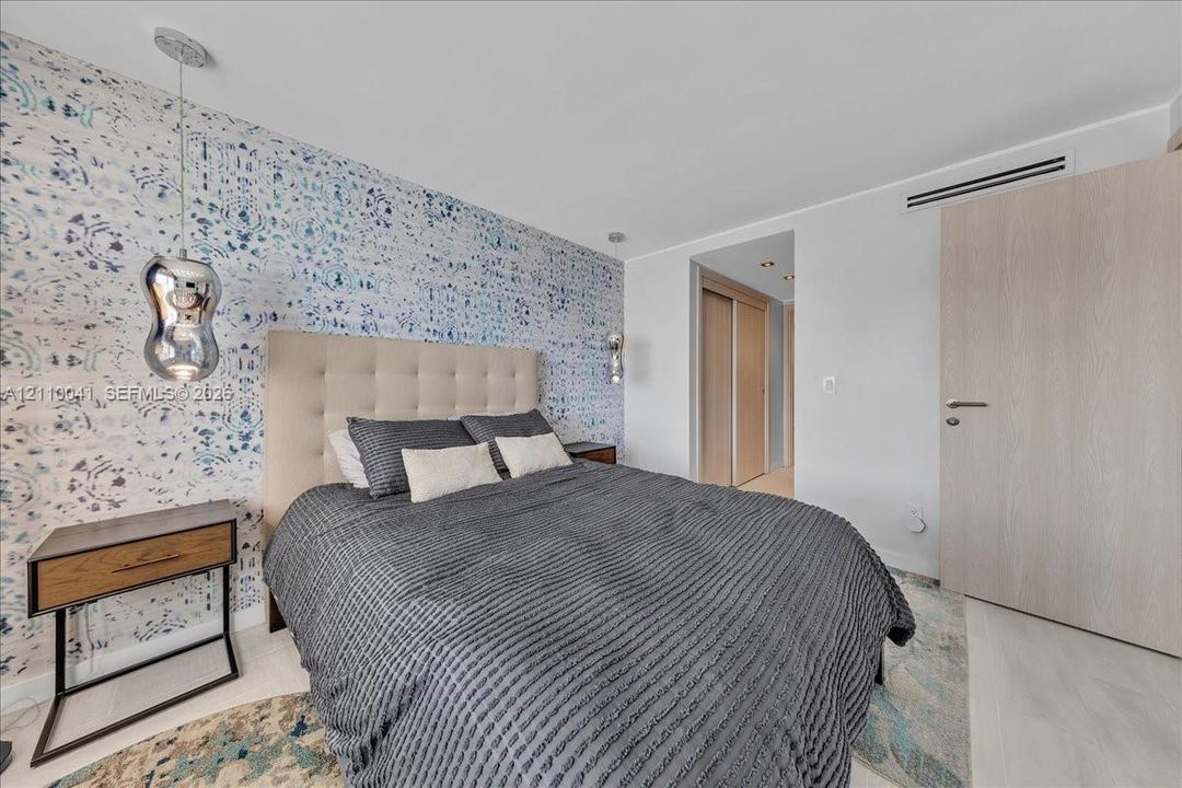 Patterned accent wallpaper, metallic pendant lighting, wood-finish interior door, and integrated climate control system