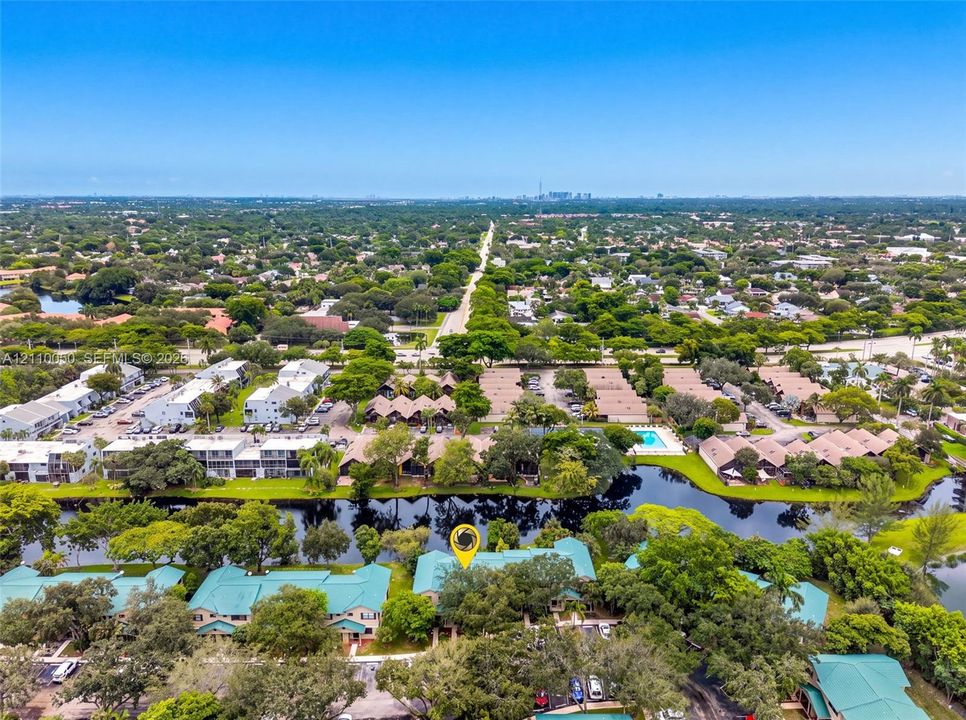 Aerial perspective of the property featuring waterfront positioning, expansive tree canopy coverage, and multi-building complex layout