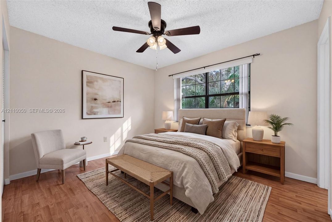 Wood-finish flooring, multi-pane window with grid detailing, and ceiling fan with integrated light fixture