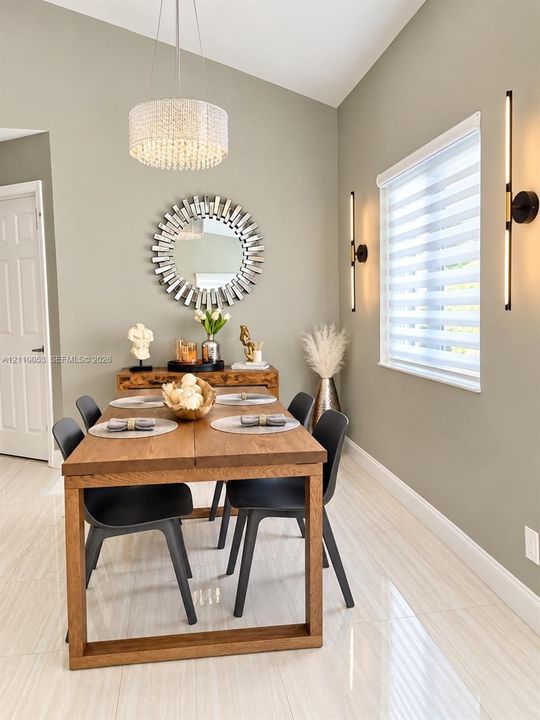 Wood-finish flooring, neutral wall tones, multi-tier drum ceiling fixture with crystal accents, and window with integrated blind system