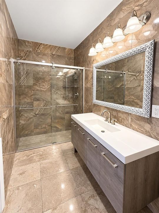 Wood-finish flooring, brushed nickel finish ceiling fan with integrated lighting, and louvered closet doors