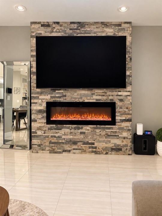 Vaulted ceilings, large-format tile flooring, drum-style chandelier, and vertical matte black wall sconces