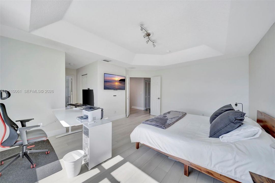 Tray ceiling, wood-finish flooring, and multi-directional track lighting