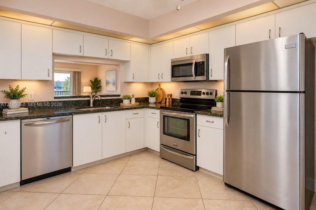 Kitchen featuring white cabinetry, dark stone countertops, stainless steel appliances, under-cabinet lighting, and tile flooring