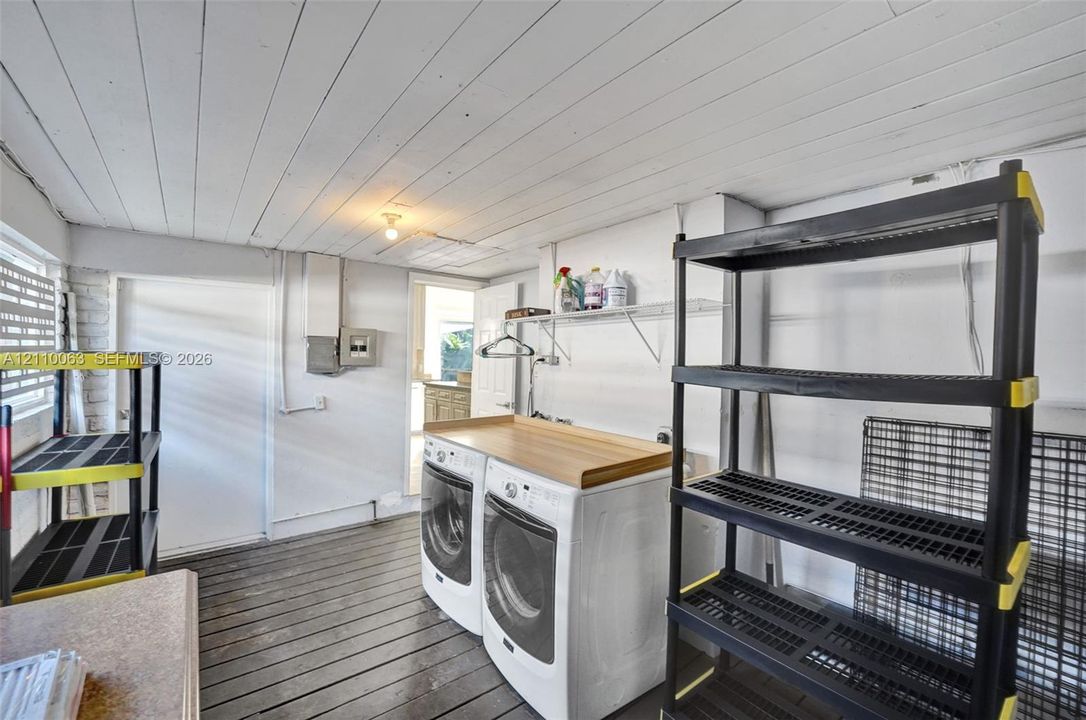 Laundry area featuring a wood-plank ceiling, wood-finish flooring, and wall-mounted shelving