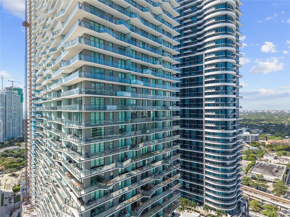 High-rise architecture featuring serrated glass-railed balconies and floor-to-ceiling windows