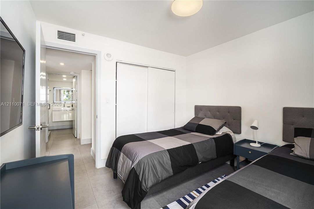 Neutral-toned room featuring hard-surface flooring, a dual-door closet, and flush-mount ceiling lighting