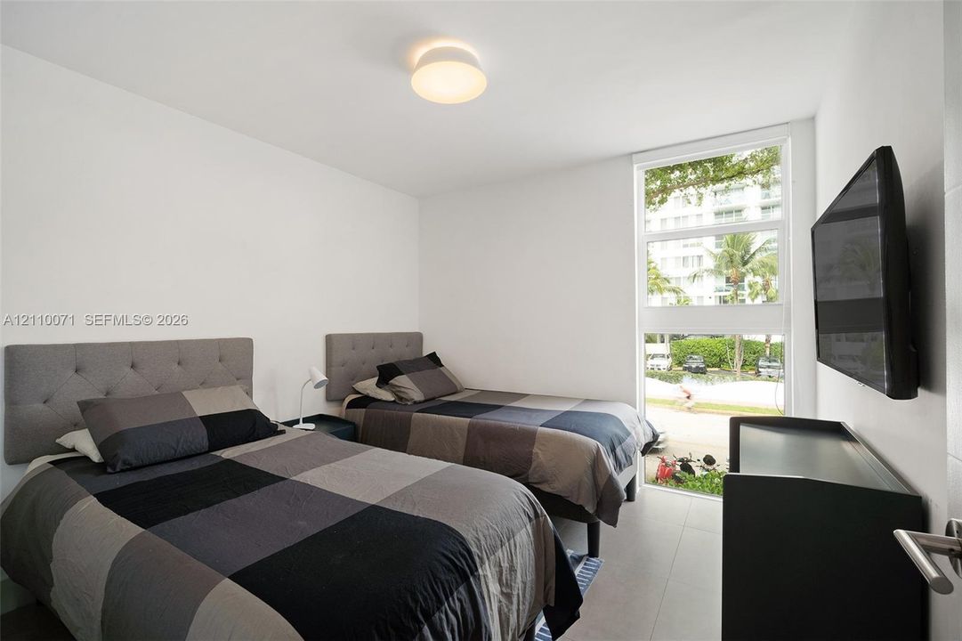 Minimalist room featuring large-format tile flooring, a floor-to-ceiling vertical window, and a flush-mount dome light fixture