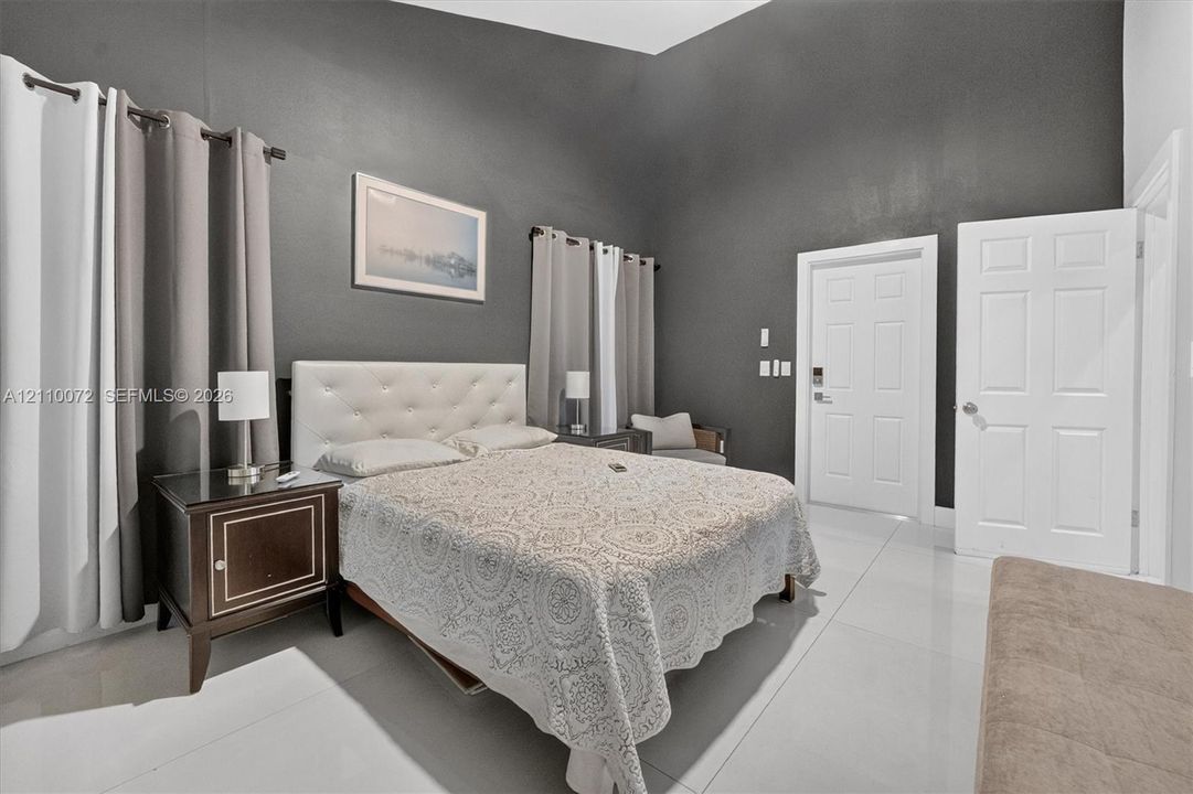 Vaulted ceilings, large-format tile flooring, and dual white six-panel doors