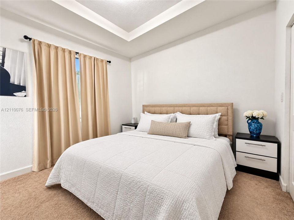 Tray ceiling, neutral wall tones, and wall-to-wall carpeting