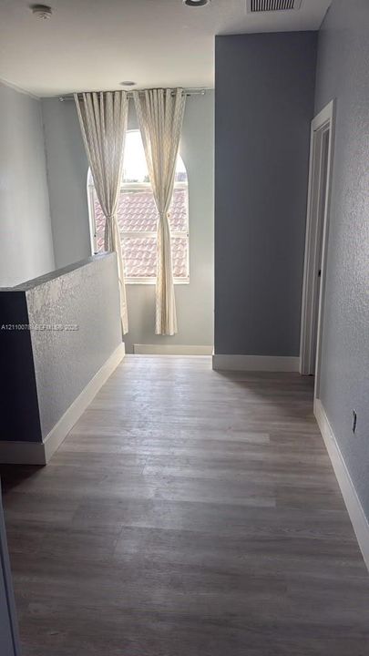 Wood-finish flooring, arched window, and recessed ceiling lighting