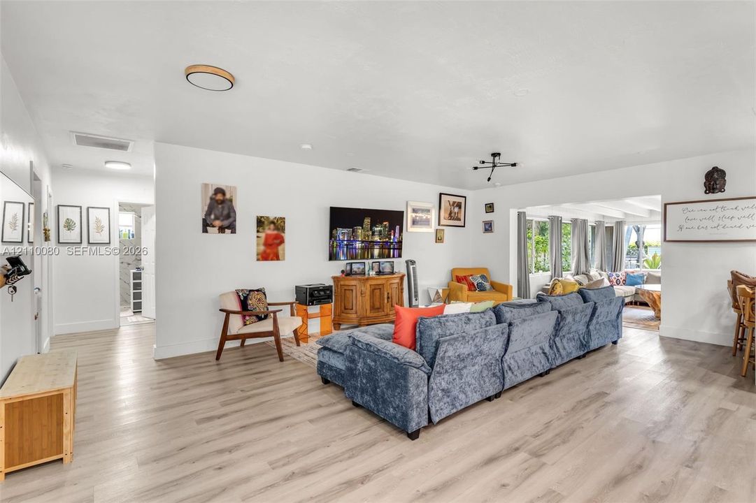 Living area featuring wood-finish flooring, recessed ceiling lighting, and a modern multi-arm chandelier