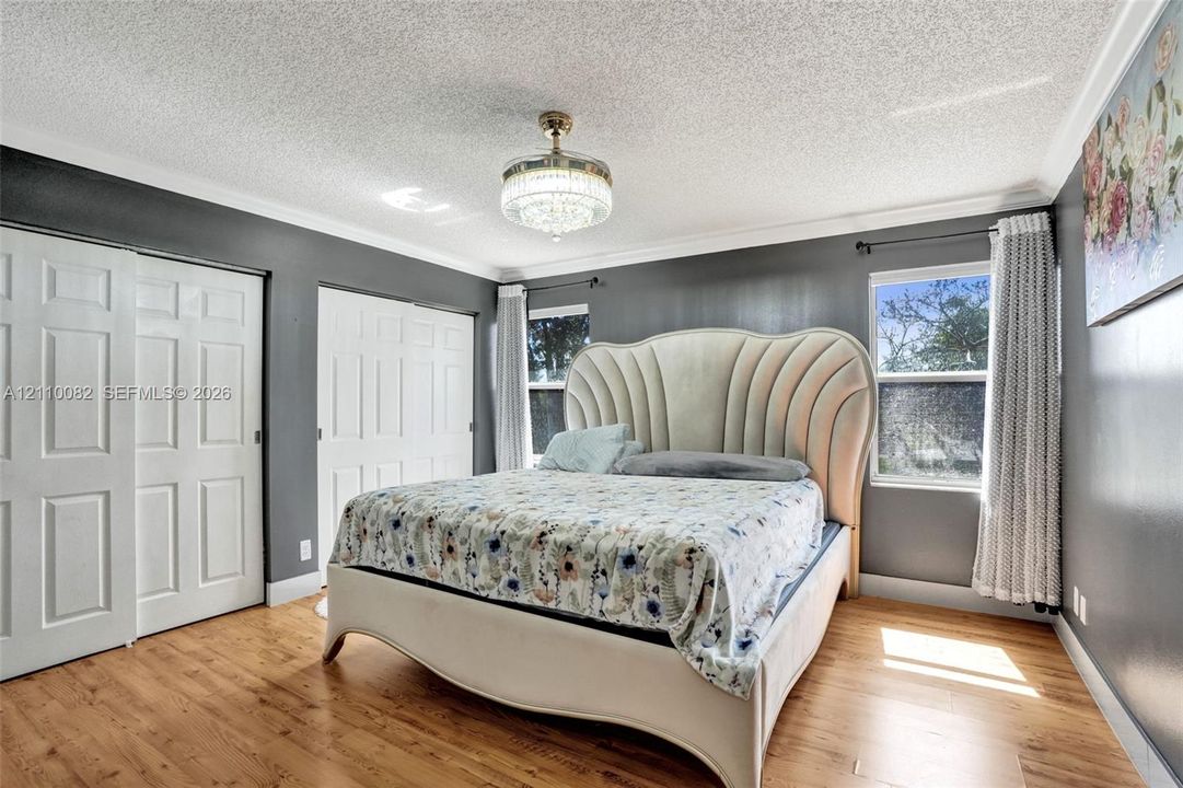 Wood-finish flooring, crystal-accented chandelier fixture, dual pane windows, and multi-panel closet doors
