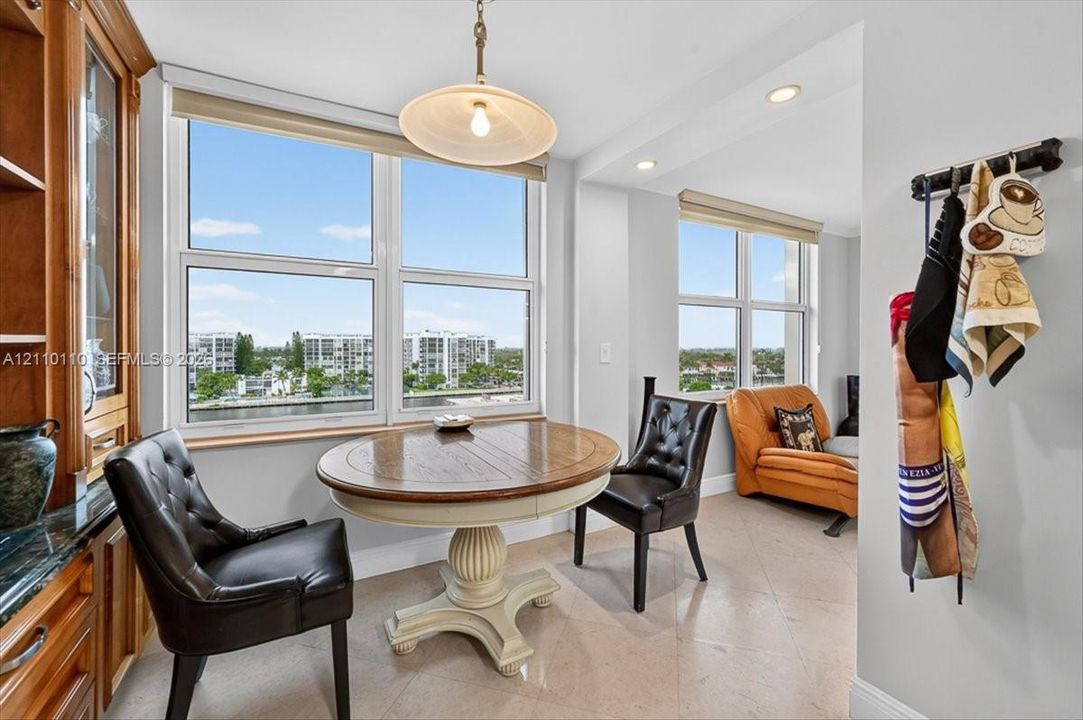 Built-in wood cabinetry, large multi-pane windows, recessed ceiling lighting, pendant light fixture, and stone-finish tile flooring