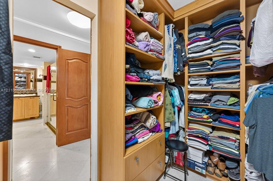 Custom floor-to-ceiling wooden built-in cabinetry featuring open shelving and integrated drawer storage