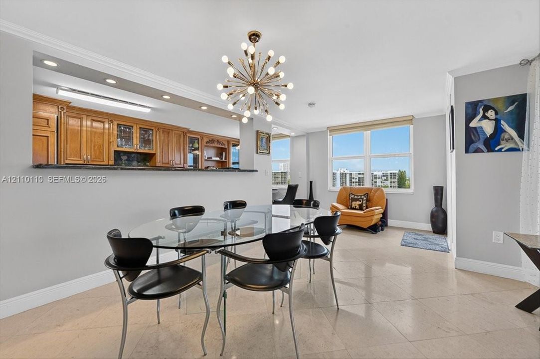 Open-concept dining area featuring stone flooring, a multi-light starburst chandelier, and recessed lighting