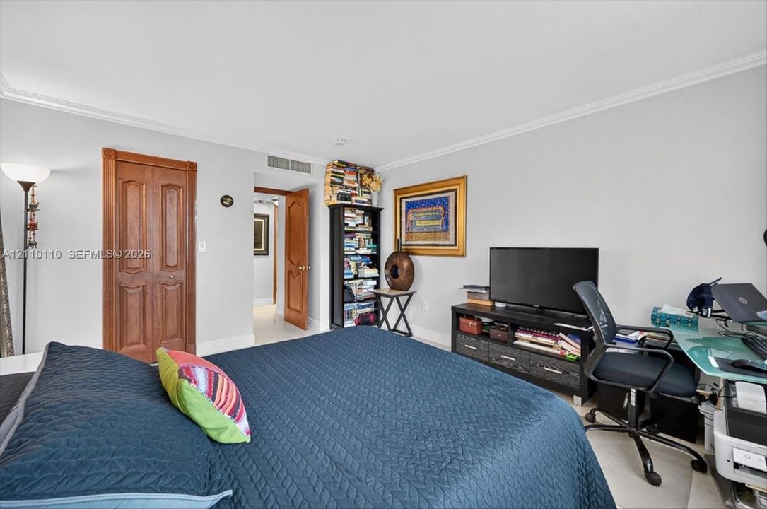 Neutral wall tones, crown molding, and wood-finish interior doors