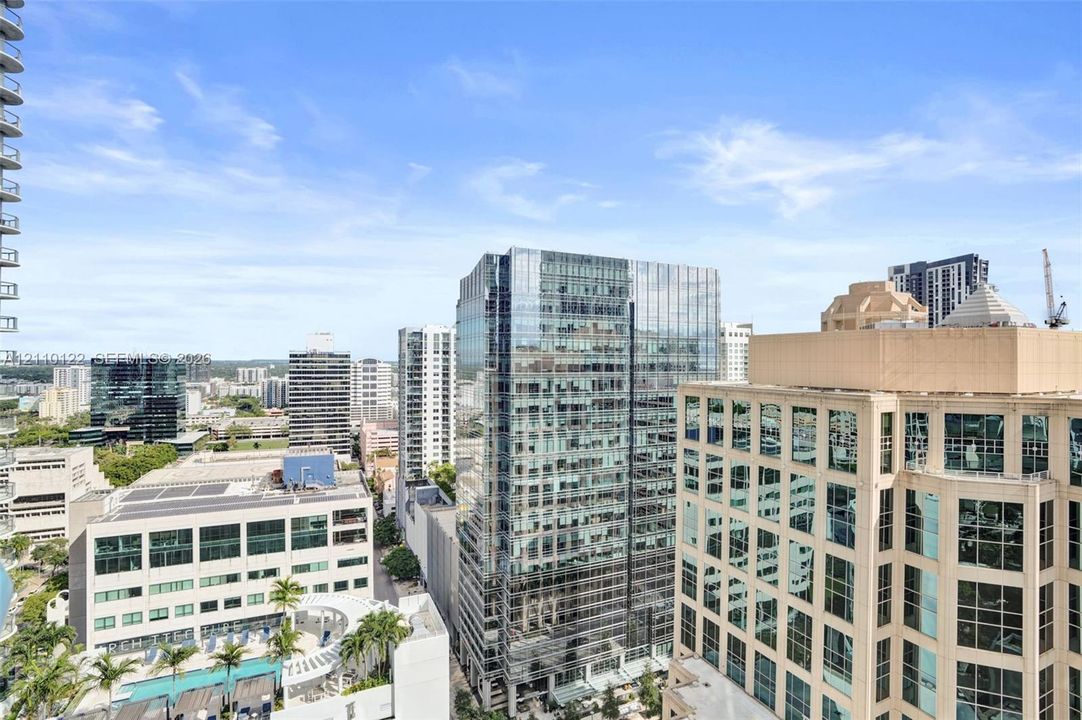 Elevated urban setting showcasing high-rise architecture, glass-paneled facades, and mature palm trees