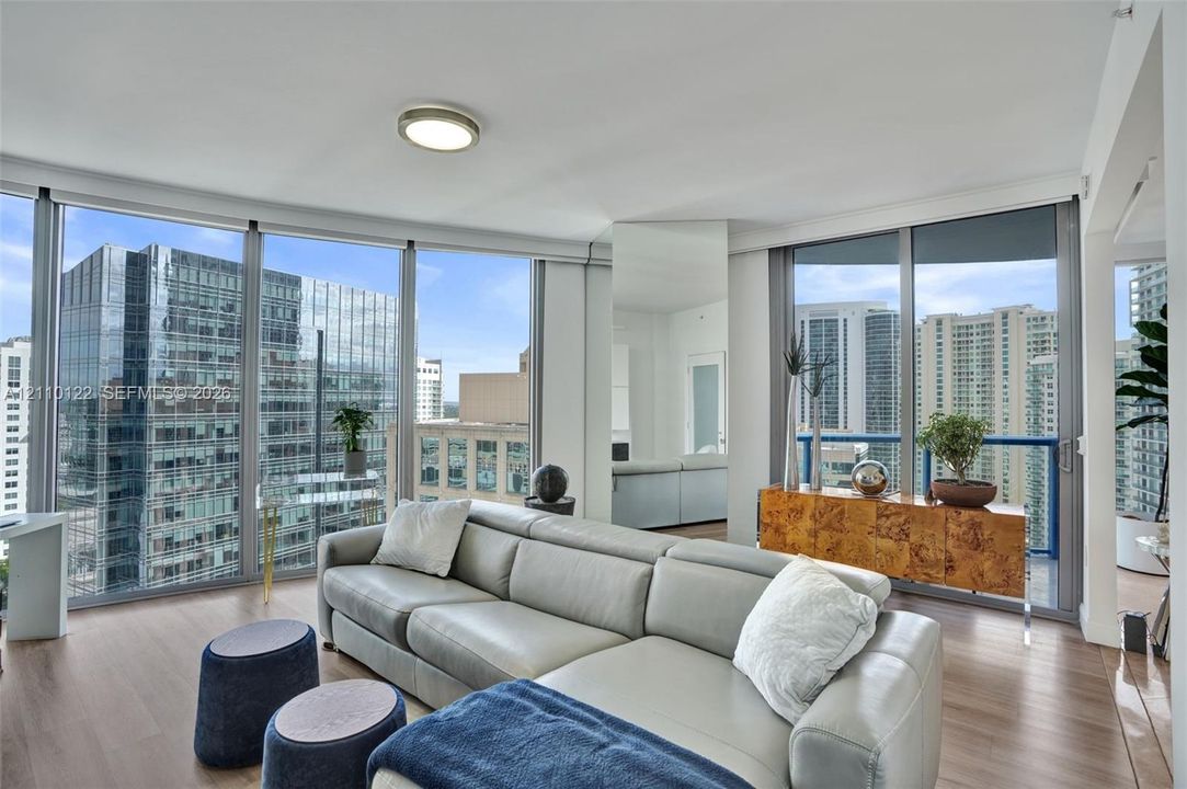 Floor-to-ceiling windows, wood-finish flooring, and recessed ceiling lighting