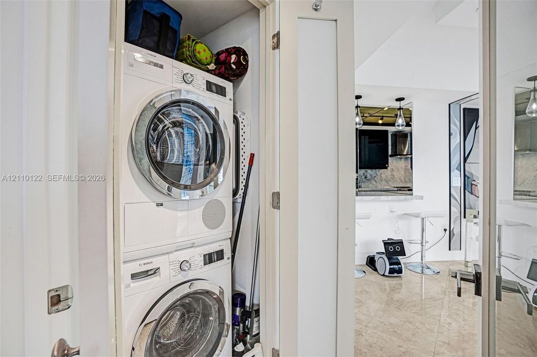 Stackable Bosch front-load washer and dryer unit housed within a dedicated closet