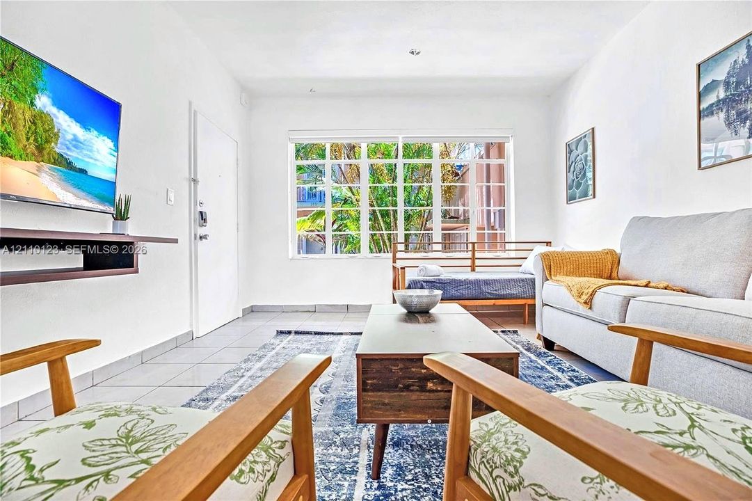 Living space featuring large multi-pane windows and tile flooring
