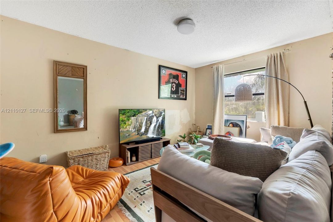 Room featuring wood-finish flooring, a window, and a flush-mount ceiling light fixture