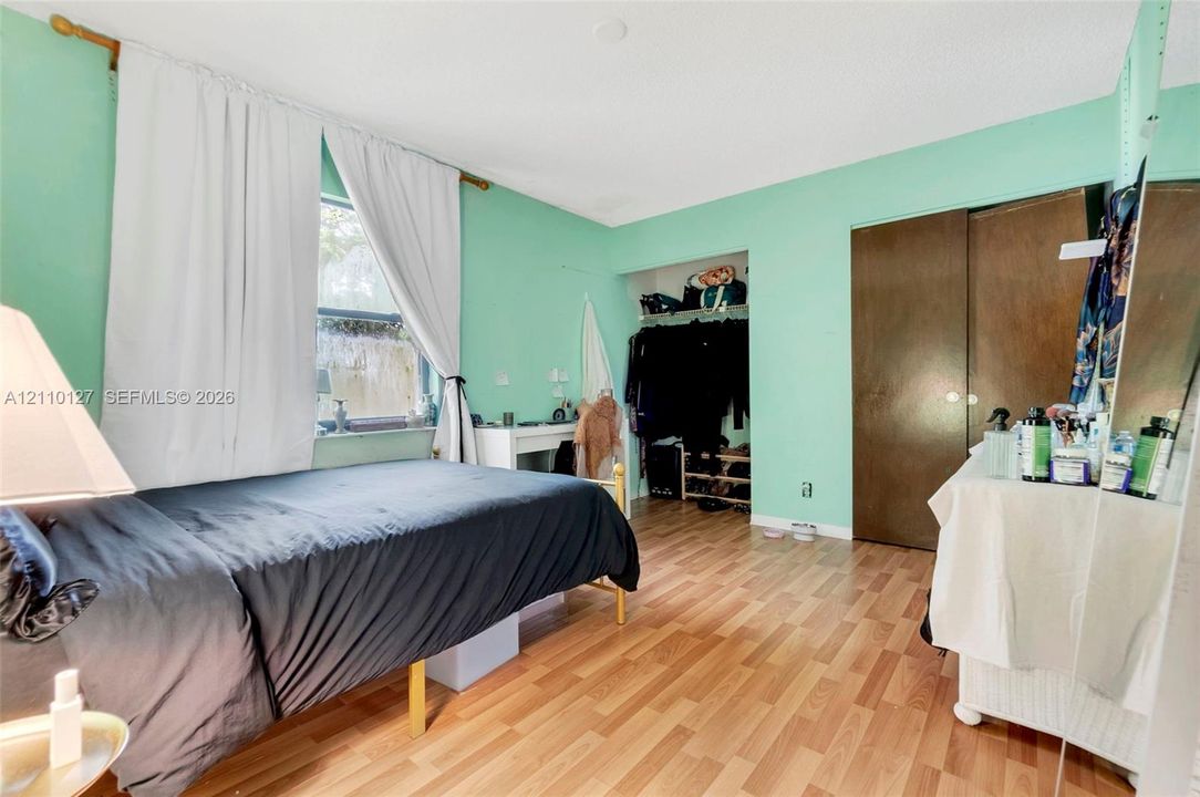 Wood-finish flooring, sliding closet doors, and a built-in recessed closet storage area