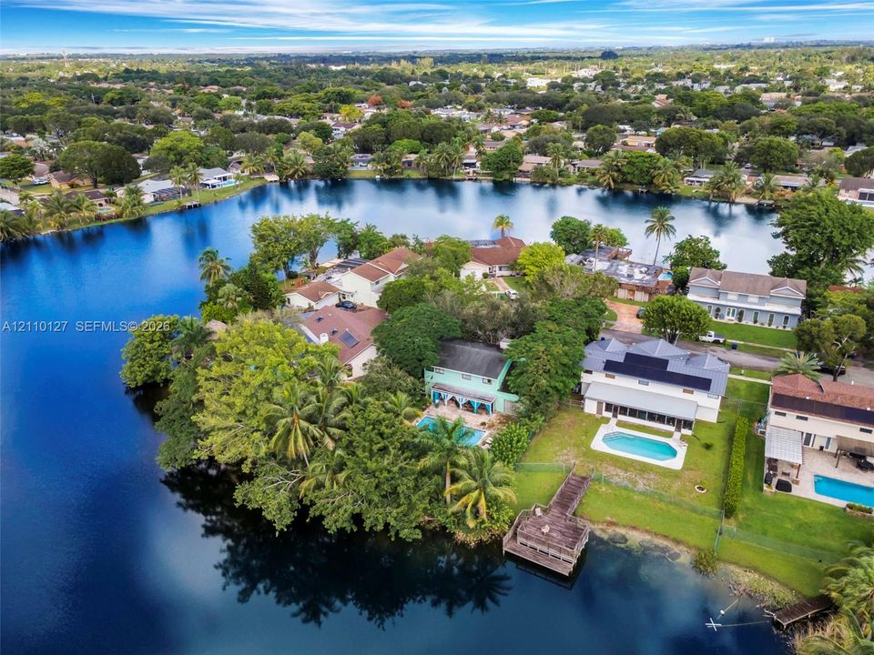 Aerial perspective of waterfront properties featuring deep-water access, private swimming pools, and dedicated dock structures