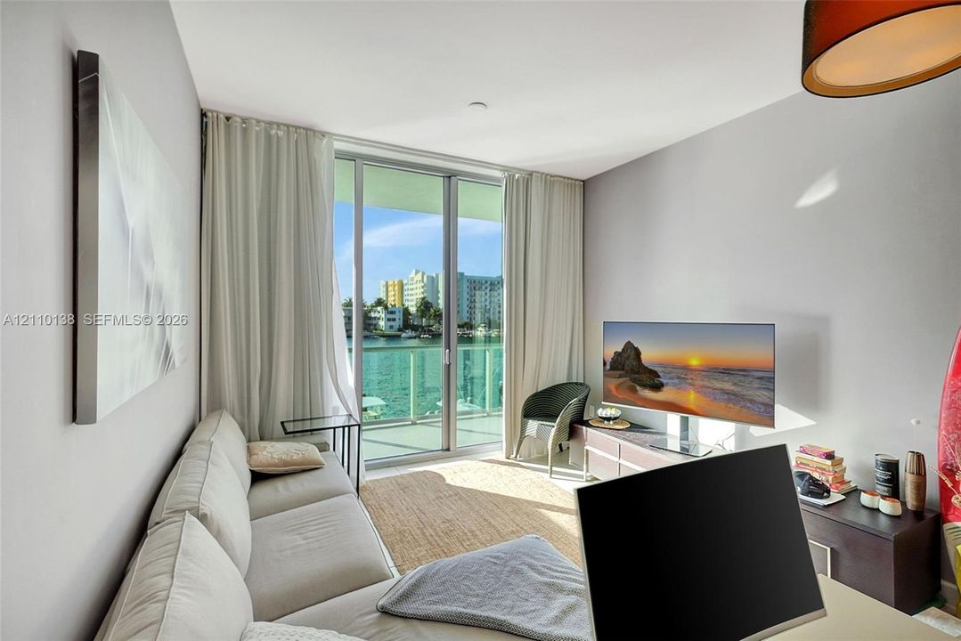 Floor-to-ceiling sliding glass door, glass-panel balcony railing, and water-facing exterior