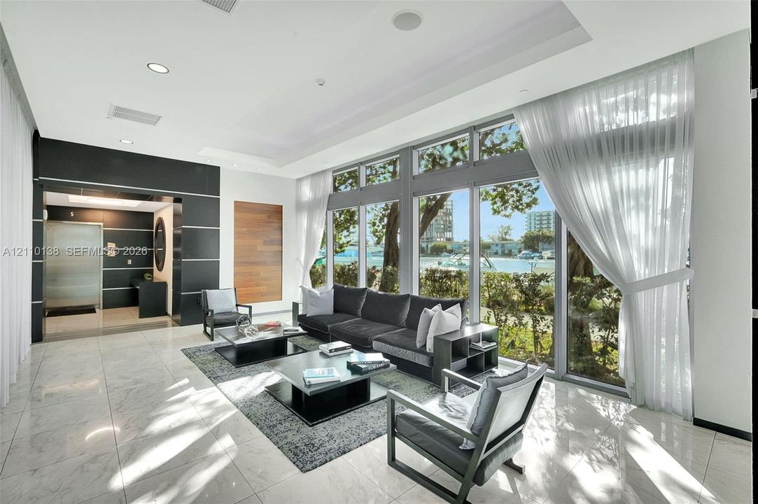 Floor-to-ceiling windows, high-gloss stone tile flooring, recessed ceiling lighting, and wood panel wall accents