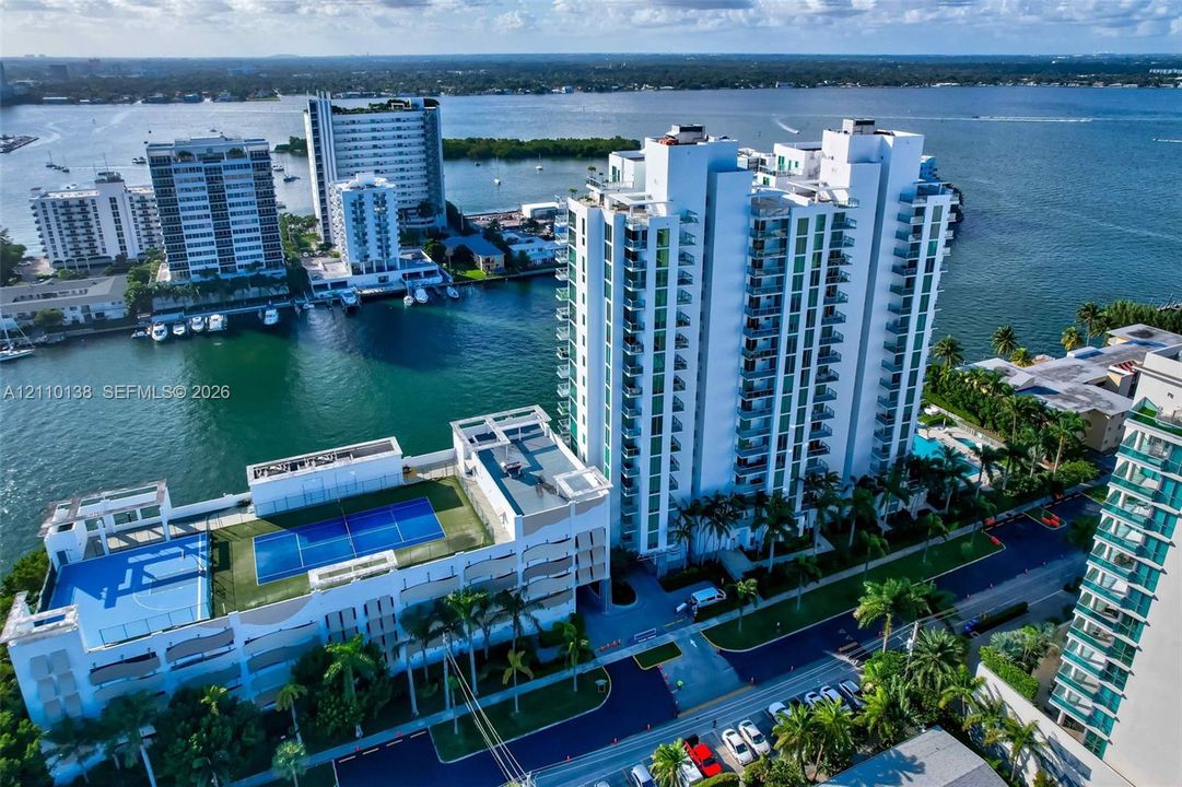 Waterfront high-rise featuring private tennis courts, a dedicated swimming pool, and balconies on each level