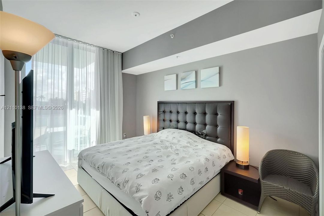 Floor-to-ceiling glass door, neutral interior paint palette, and ceramic tile flooring